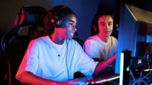 a girl and boy wearing headsets playing a computer game