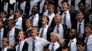 Boys in their school uniform holding on to each other