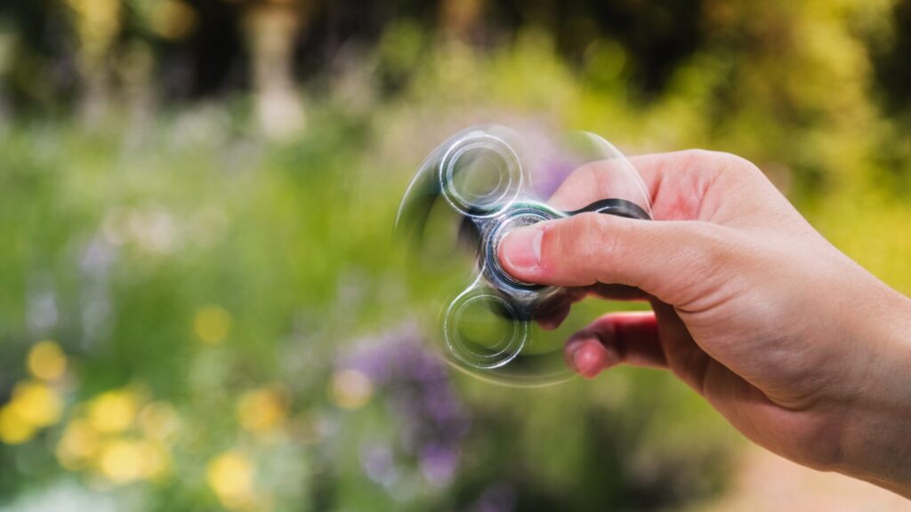 Person using a fidget spinner in the garden