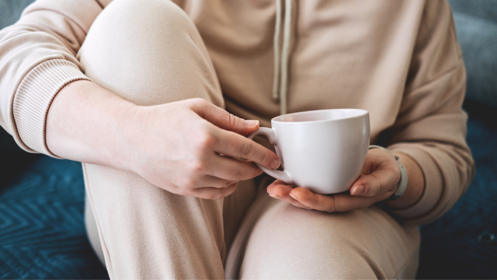 Teenager holding a mug of tea in their hands