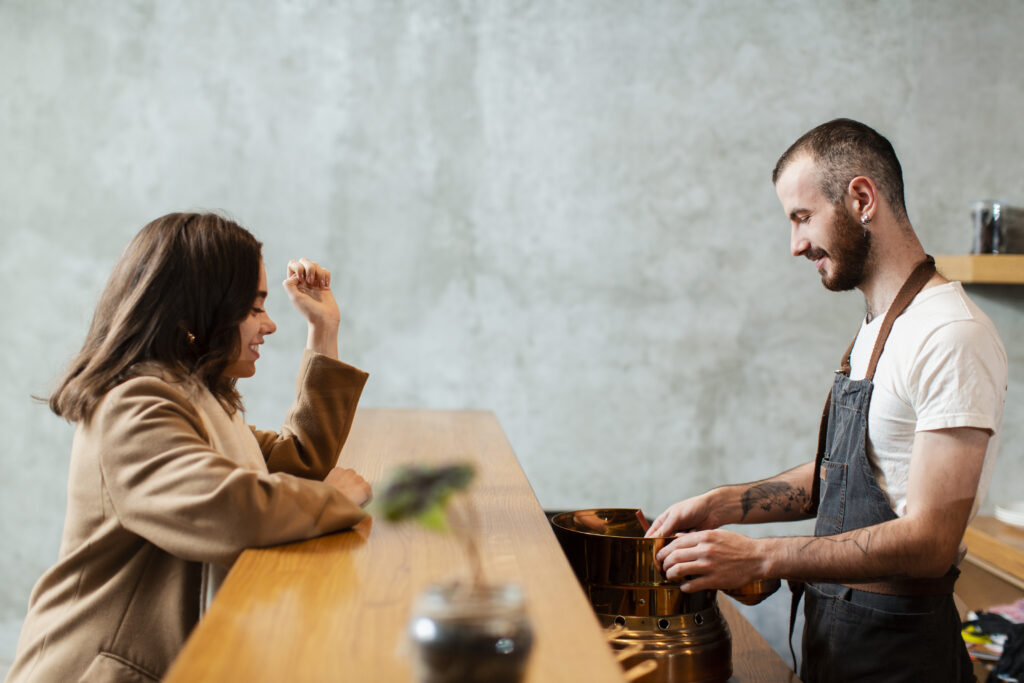 Woman ordering a drink from a waiter at a cafe 