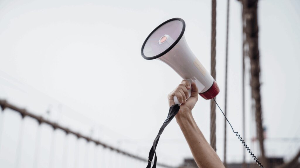 Person holding a megaphone up in the air