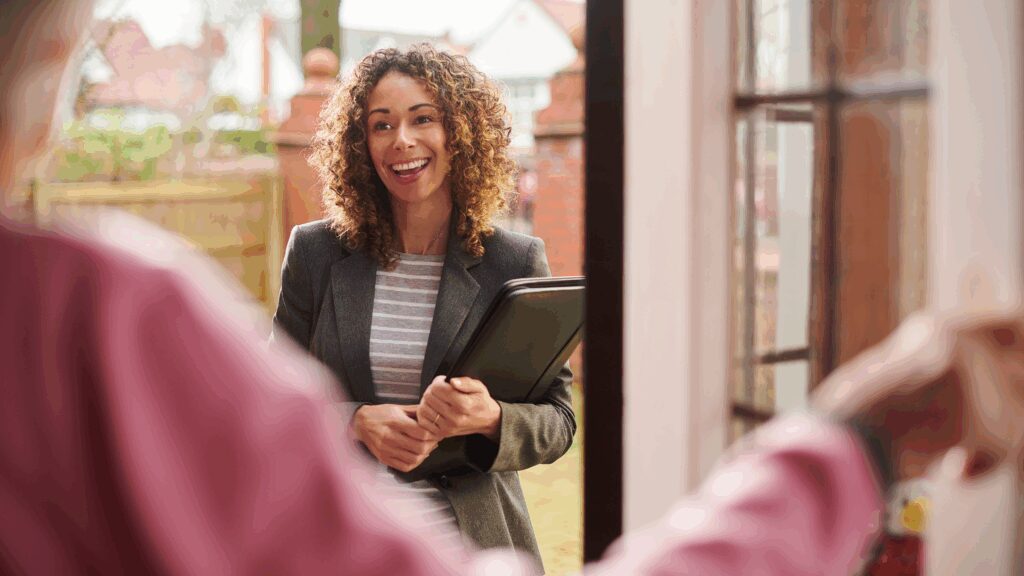 Social worker at a young persons door, smiling