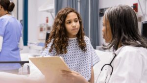 Young teen girl talking to doctor about periods